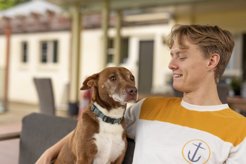 participant with his dog relaxing in safe and comfortable SIL home environment